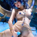 photo - 这张图片展示了一位女性角色的Cosplay（角色扮演），从发型和整体色调来看，她正扮演的是游戏《原神》中的角色莱依拉。

该女子留着长长的深蓝色卷发，点缀着金色